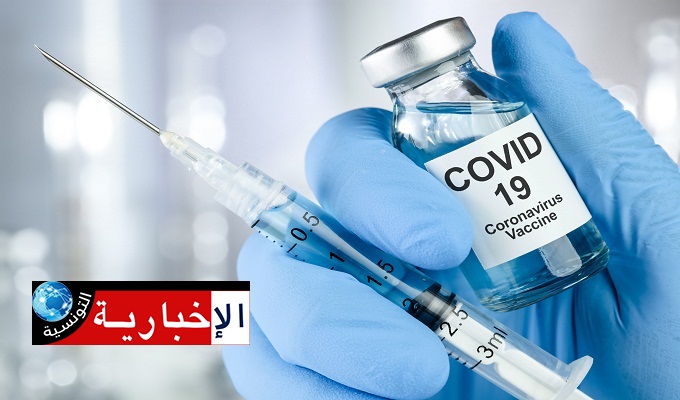 Healthcare cure concept with a hand in blue medical gloves holding Coronavirus, Covid 19 virus, vaccine vial
